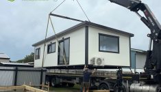A Cosy Home being craned on to timber piles, use in high flood plain areas