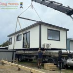A Cosy Home being craned on to timber piles, use in high flood plain areas