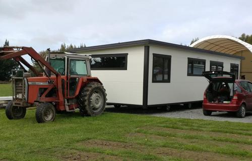 A Cosy Home being moved on its wheels by a tractor